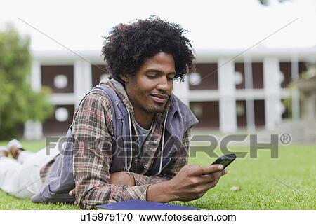 Student using cell phone on grass View Large Photo Image Stock Image - Student using cell phone on grass. Fotosearch