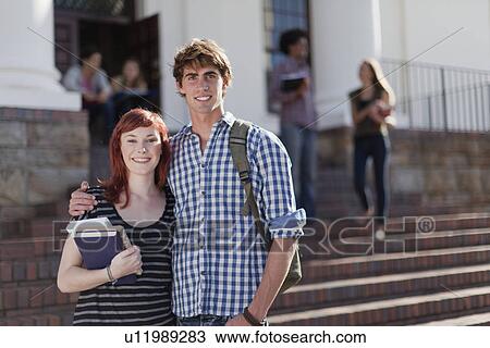 Stock Image - Students hugging on campus. Fotosearch