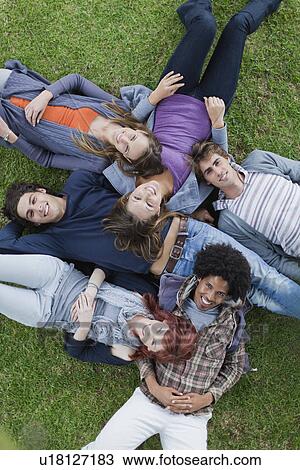 Students laying in grass on campus View Large Photo Image Stock Image - Students laying in grass on campus. Fotosearch