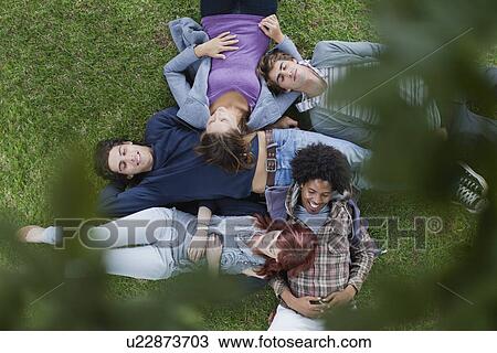 Students laying in grass on campus View Large Photo Image Stock Image - Students laying in grass on campus. Fotosearch