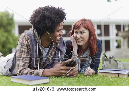Stock Image - Students listening to mp3 player. Fotosearch