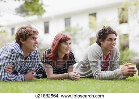 Students relaxing on grass on campus View Large Photo Image Picture - Students relaxing on grass on campus. Fotosearch
