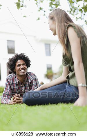 Stock Photo - Students relaxing on grass on campus. Fotosearch