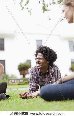 Students relaxing on grass on campus View Large Photo Image Stock Photo - Students relaxing on grass on campus. Fotosearch