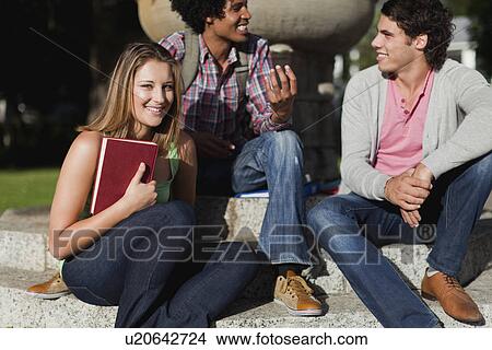 Picture - Students sitting together on campus. Fotosearch