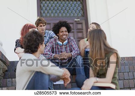 Stock Image - Students sitting together on campus. Fotosearch