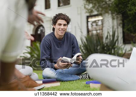 Stock Image - Students studying on grass on campus. Fotosearch