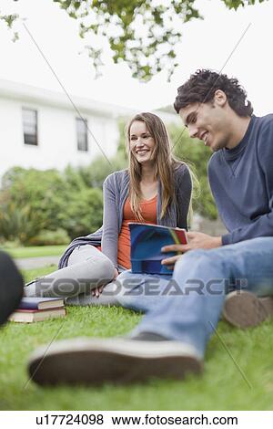 Students studying on grass on campus View Large Photo Image Stock Photo - Students studying on grass on campus. Fotosearch