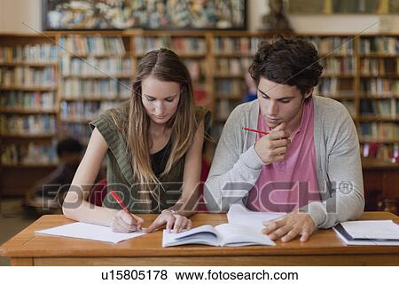 Stock Photo - Students studying together in library. Fotosearch