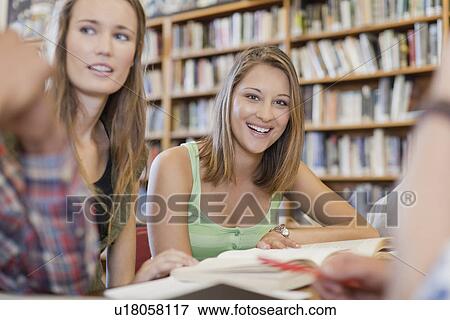 Stock Photo - Students studying together in library. Fotosearch