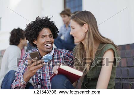 Stock Photograph - Students using cell phone on campus. Fotosearch
