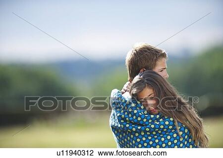 Teenage couple wrapped in blanket View Large Photo Image Stock Image - Teenage couple wrapped in blanket. Fotosearch