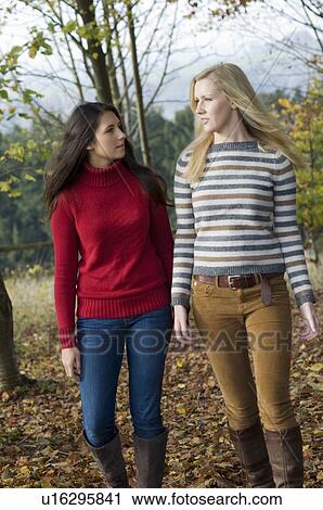 Stock Image - Teenage girls walking in park. Fotosearch