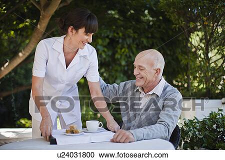 Waitress serving older man coffee View Large Photo Image Stock Image - Waitress serving older man coffee. Fotosearch