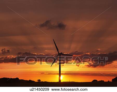 Stock Photo - Wind turbine against sunset sky. Fotosearch