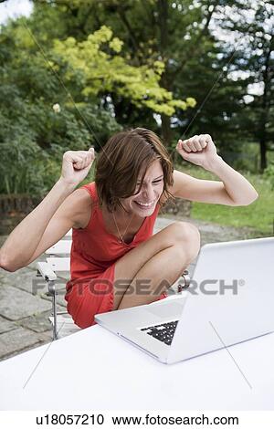 Woman cheering at laptop outdoors View Large Photo Image Stock Image - Woman cheering at laptop outdoors. Fotosearch