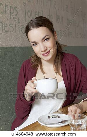 Woman drinking cup of coffee in cafe View Large Photo Image Stock Photo - Woman drinking cup of coffee in cafe. Fotosearch