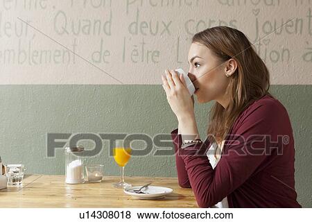 Stock Photo - Woman having cup of coffee in cafe. Fotosearch