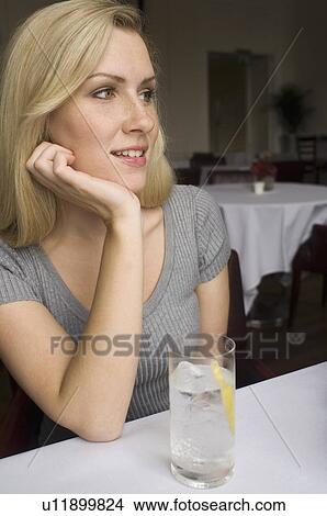 Woman having glass of water in cafe View Large Photo Image Picture - Woman having glass of water in cafe. Fotosearch