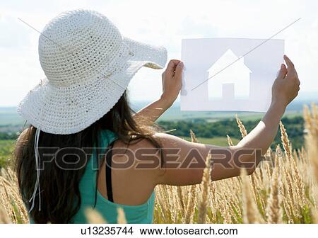 Woman holding paper house cut out View Large Photo Image Picture - Woman holding paper house cut out. Fotosearch