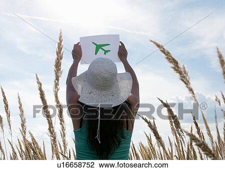 Woman holding picture of airplane in sky View Large Photo Image Stock Image - Woman holding picture of airplane in sky. Fotosearch