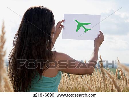 Woman holding picture of airplane in sky View Large Photo Image Stock Photograph - Woman holding picture of airplane in sky. Fotosearch