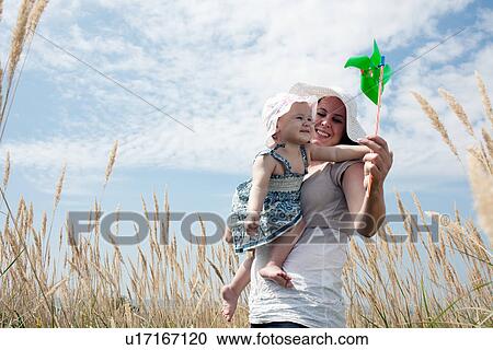 Woman holding pinwheel for daughter View Large Photo Image Stock Image - Woman holding pinwheel for daughter. Fotosearch