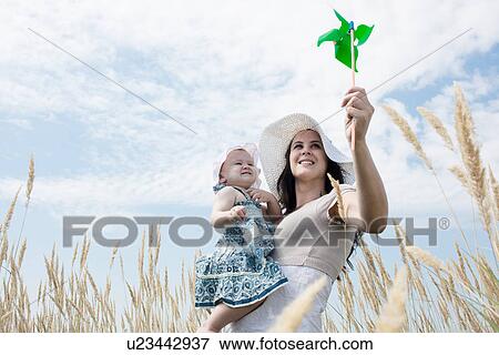 Woman holding pinwheel for daughter View Large Photo Image Stock Photo - Woman holding pinwheel for daughter. Fotosearch