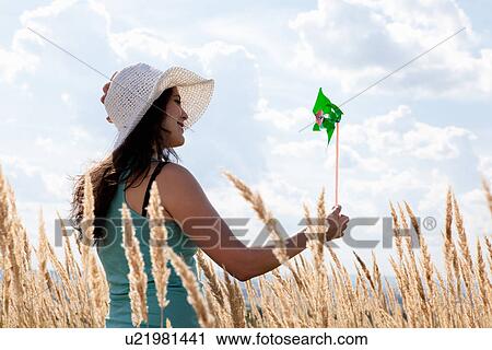Woman holding pinwheel in wheatfield View Large Photo Image Stock Image - Woman holding pinwheel in wheatfield. Fotosearch