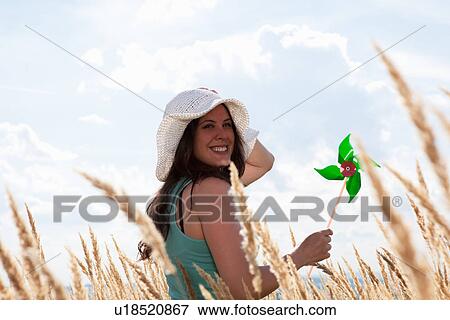 Woman holding pinwheel in wheatfield View Large Photo Image Stock Photo - Woman holding pinwheel in wheatfield. Fotosearch