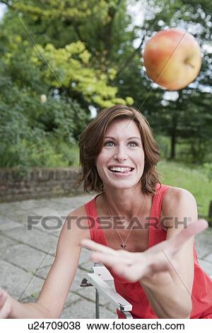 Woman juggling fruit in backyard View Large Photo Image Stock Photo - Woman juggling fruit in backyard. Fotosearch