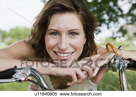 Woman leaning on bicycle outdoors View Large Photo Image Stock Photography - Woman leaning on bicycle outdoors. Fotosearch
