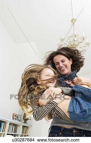 Woman playing with daughter in kitchen View Large Photo Image Picture - Woman playing with daughter in kitchen. Fotosearch