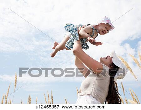 Woman playing with daughter outdoors View Large Photo Image Stock Photo - Woman playing with daughter outdoors. Fotosearch