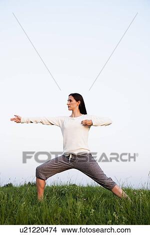 Picture - Woman practicing yoga in park. Fotosearch