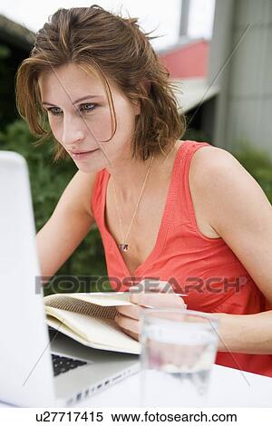Woman reading and using laptop outdoors View Large Photo Image Stock Photography - Woman reading and using laptop outdoors. Fotosearch