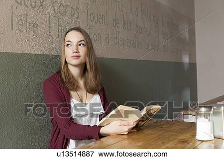 Stock Photo - Woman reading book in cafe. Fotosearch