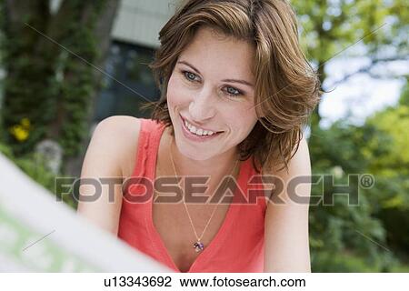 Woman reading newspaper in backyard View Large Photo Image Stock Image - Woman reading newspaper in backyard. Fotosearch