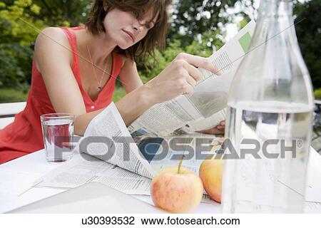 Woman reading newspaper in backyard View Large Photo Image Stock Image - Woman reading newspaper in backyard. Fotosearch