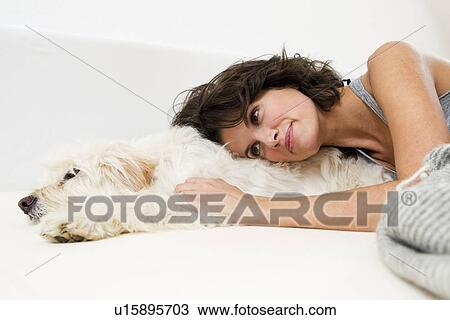 Woman relaxing in bed with dog View Large Photo Image Stock Image - Woman relaxing in bed with dog. Fotosearch