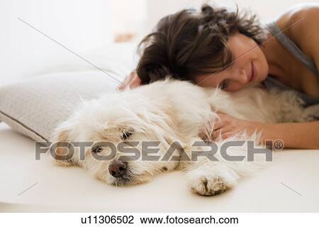 Woman relaxing with dog in bed View Large Photo Image Stock Image - Woman relaxing with dog in bed. Fotosearch