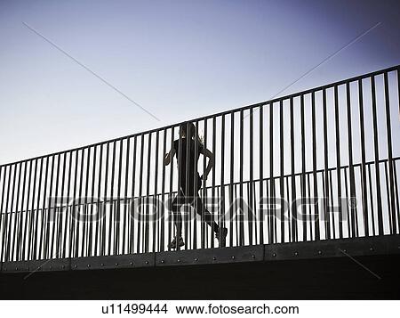 Picture - Woman running on skybridge. Fotosearch