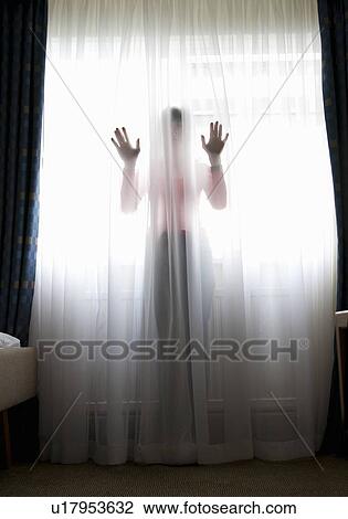 Woman standing behind sheer curtain View Large Photo Image Stock Image - Woman standing behind sheer curtain. Fotosearch