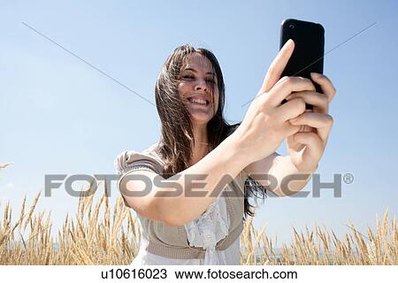 Woman taking pictures with cell phone View Large Photo Image Stock Image - Woman taking pictures with cell phone. Fotosearch
