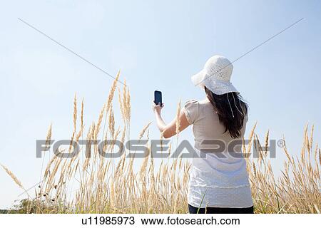 Woman taking pictures with cell phone View Large Photo Image Stock Image - Woman taking pictures with cell phone. Fotosearch