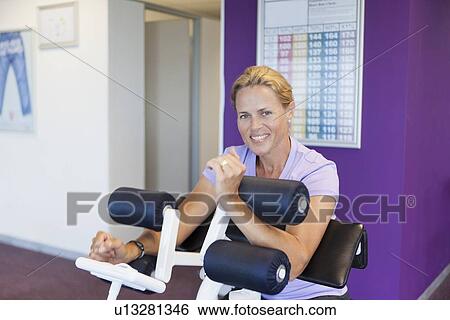 Woman using weights machine in gym View Large Photo Image Stock Photograph - Woman using weights machine in gym. Fotosearch