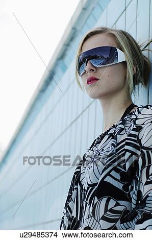 Picture - Woman wearing sunglasses in empty pool. Fotosearch