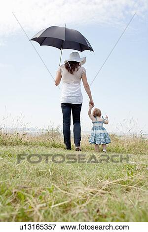 Woman with daughter and umbrella View Large Photo Image Stock Photo - Woman with daughter and umbrella. Fotosearch