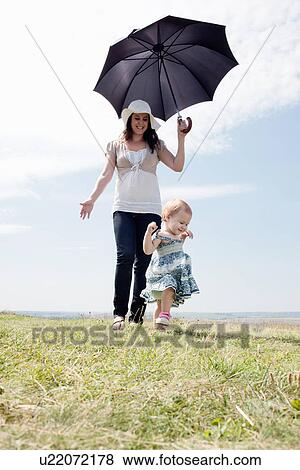 Woman with daughter and umbrella View Large Photo Image Stock Photo - Woman with daughter and umbrella. Fotosearch
