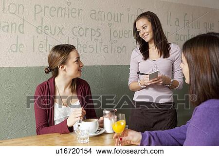 Picture - Women talking to waitress in cafe. Fotosearch